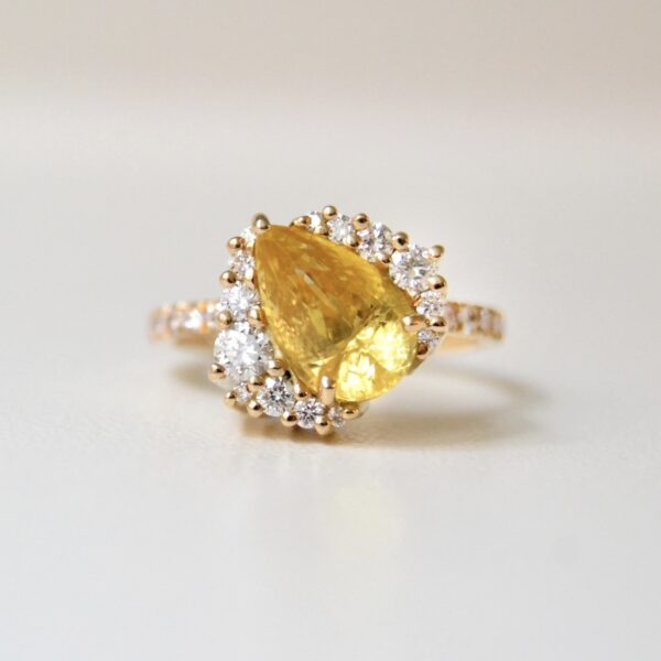 Yellow sapphire engagement ring set with diamonds in 18K yellow gold.