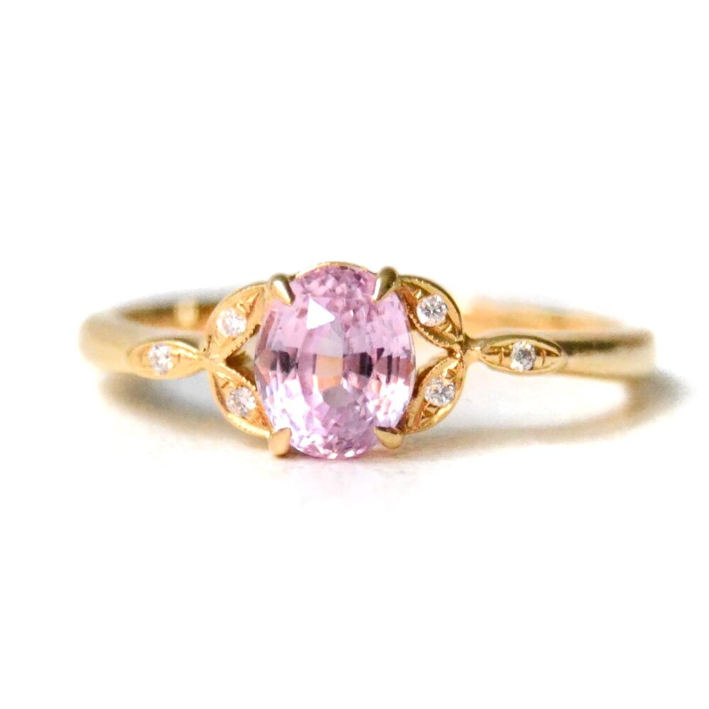 Oval pink sapphire ring set with diamonds in 18k yellow gold