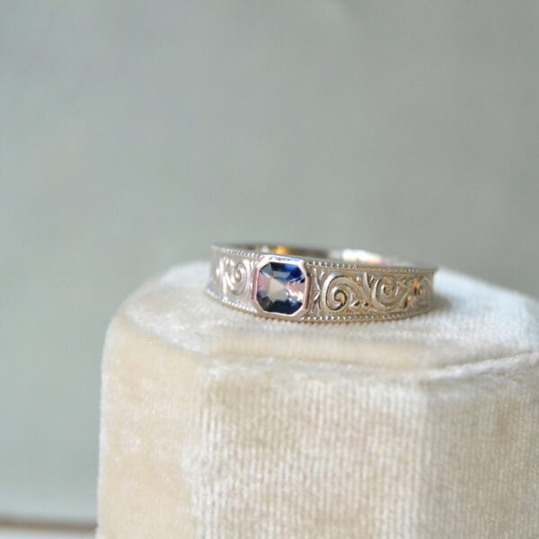 Carved ring band with bi-color sapphire