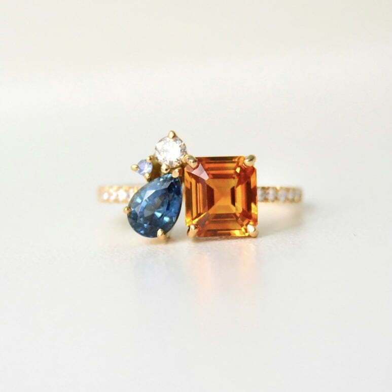 Emerald cut orange sapphire ring with teal sapphire and diamonds