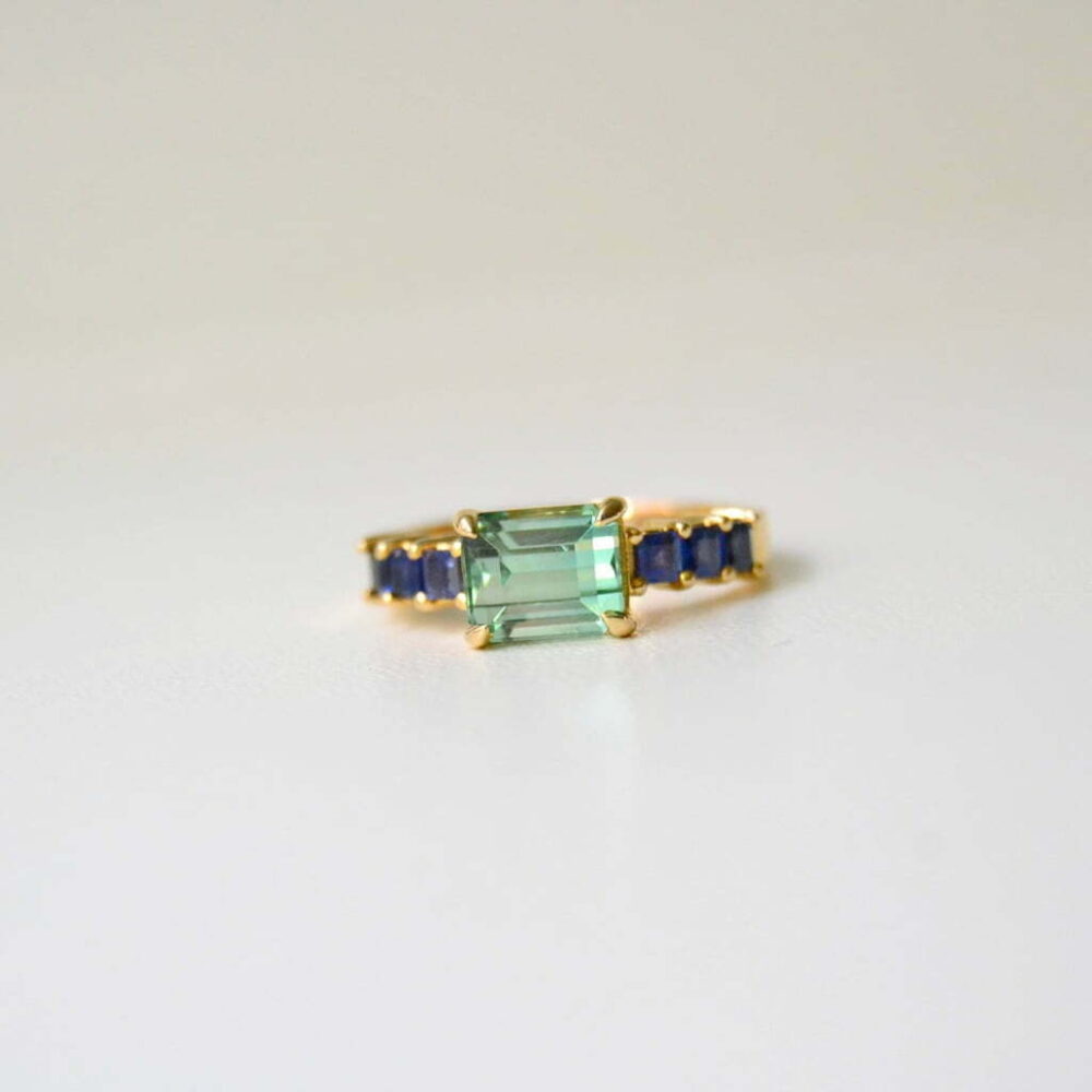 East west ring with green tourmaline and blue sapphires in 18K yellow gold