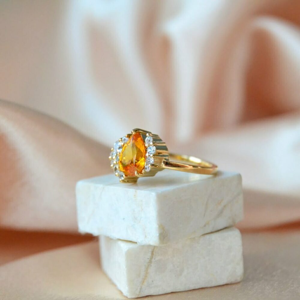 Orange sapphire asymmetric halo ring