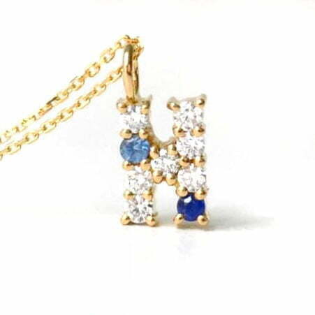 Letter pendant with diamonds and sapphires set in 18K yellow gold