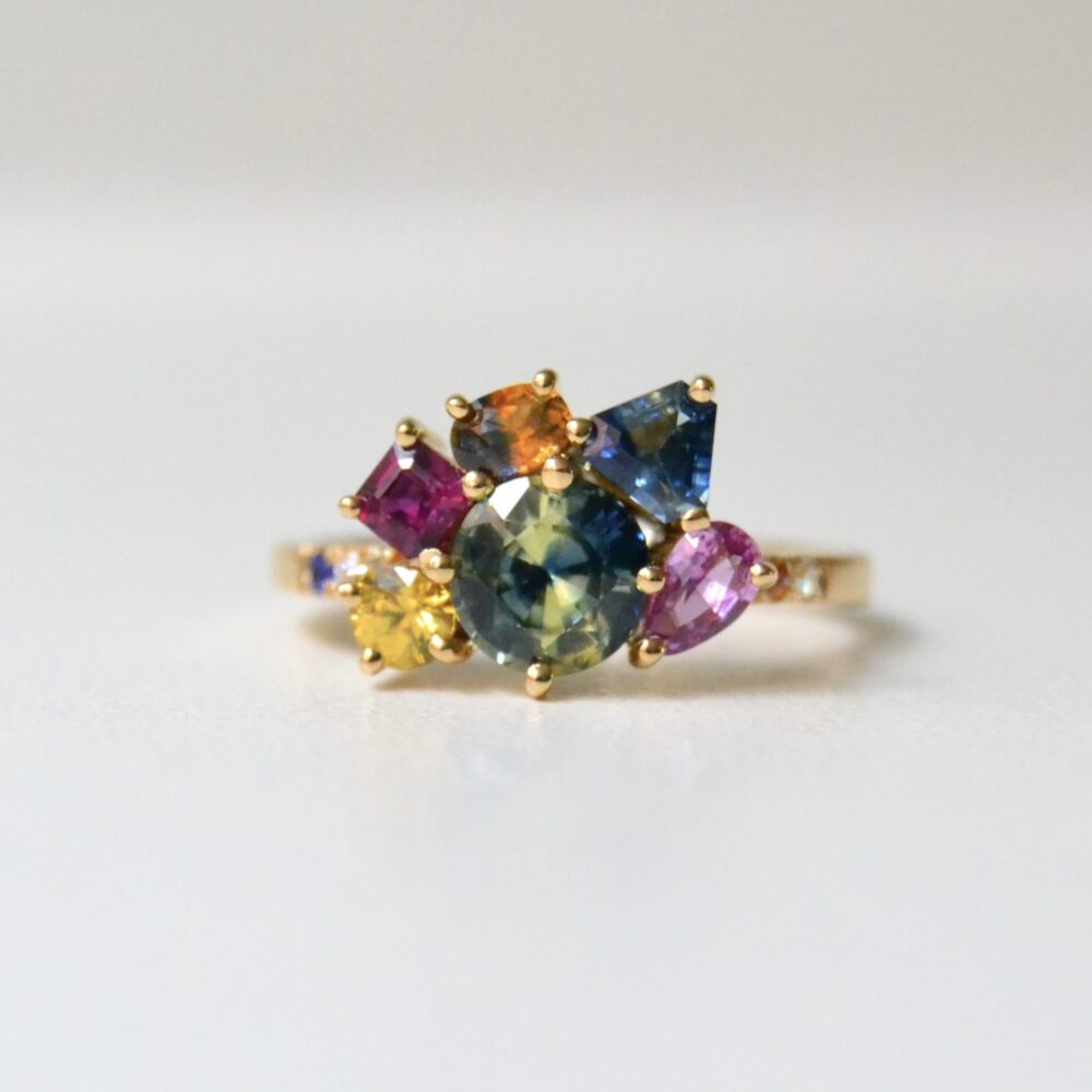 Bi-color sapphire ring with multi color sapphires and diamonds set in 18K yellow gold