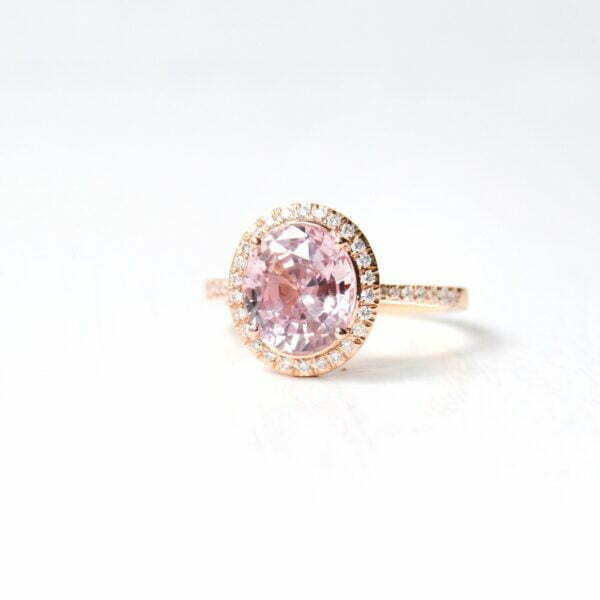 peach sapphire halo ring with diamonds set in 18K rose gold.
