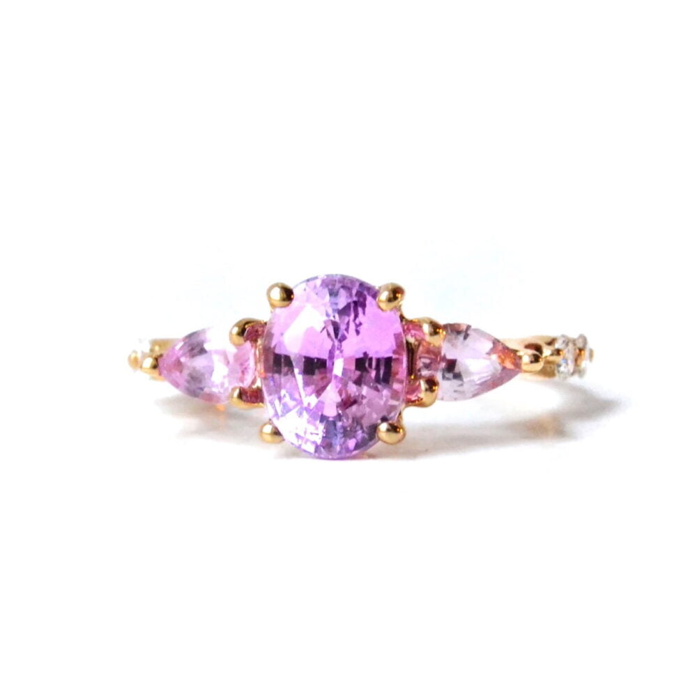 Pink sapphire three stone ring with diamonds set in 18K yellow gold