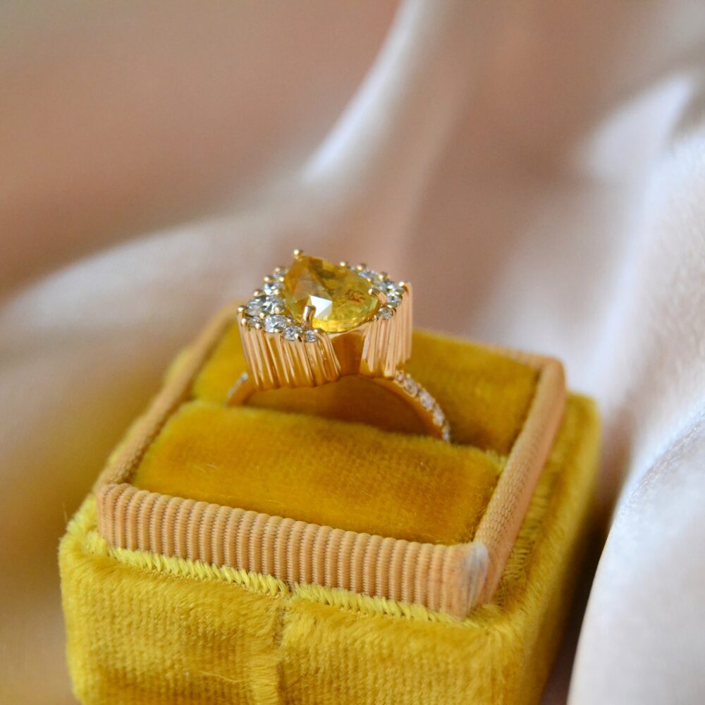 Yellow sapphire engagement ring set with diamonds in 18K yellow gold.
