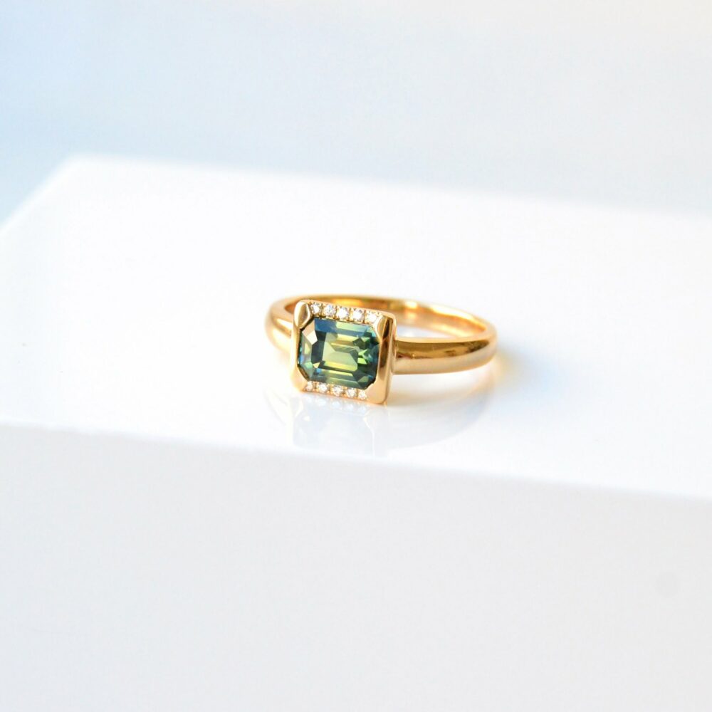 east west ring with green sapphire and diamonds set in 18K yellow gold.