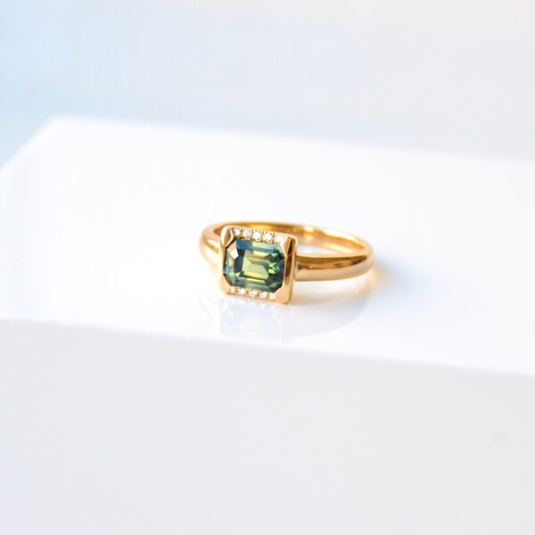 east west ring with green sapphire and diamonds set in 18K yellow gold.