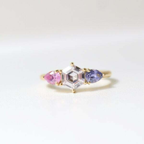 Hexagon shaped white sapphire set with pink and purple sapphires in 18K yellow gold.