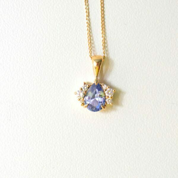 Blue sapphire pendant set with VS1-TW diamonds in 18K yellow gold.