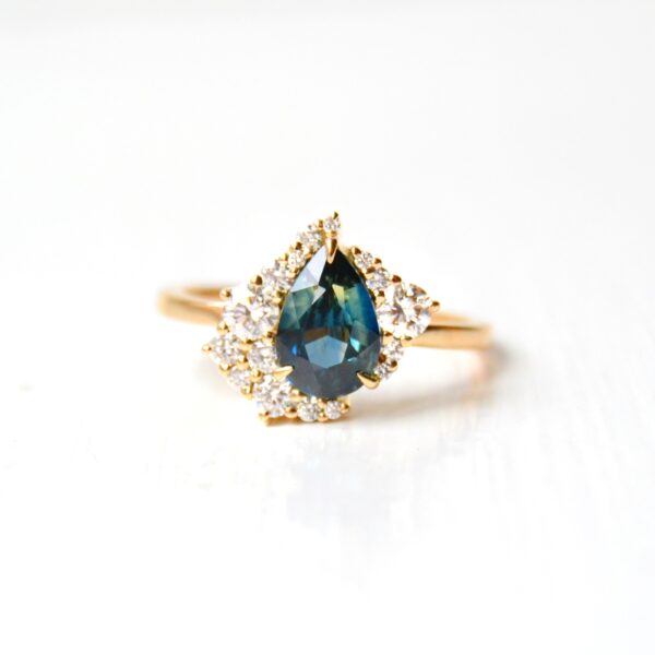 Teal sapphire ring with diamonds set in 18K yellow gold
