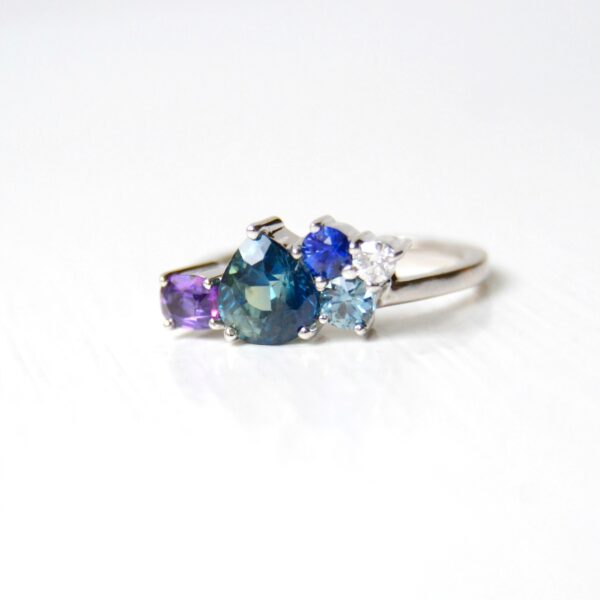 teal sapphire ring in a cluster design of 18K white gold.