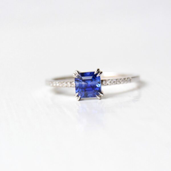 Asscher cut blue sapphire ring with diamonds set in 18K white gold.