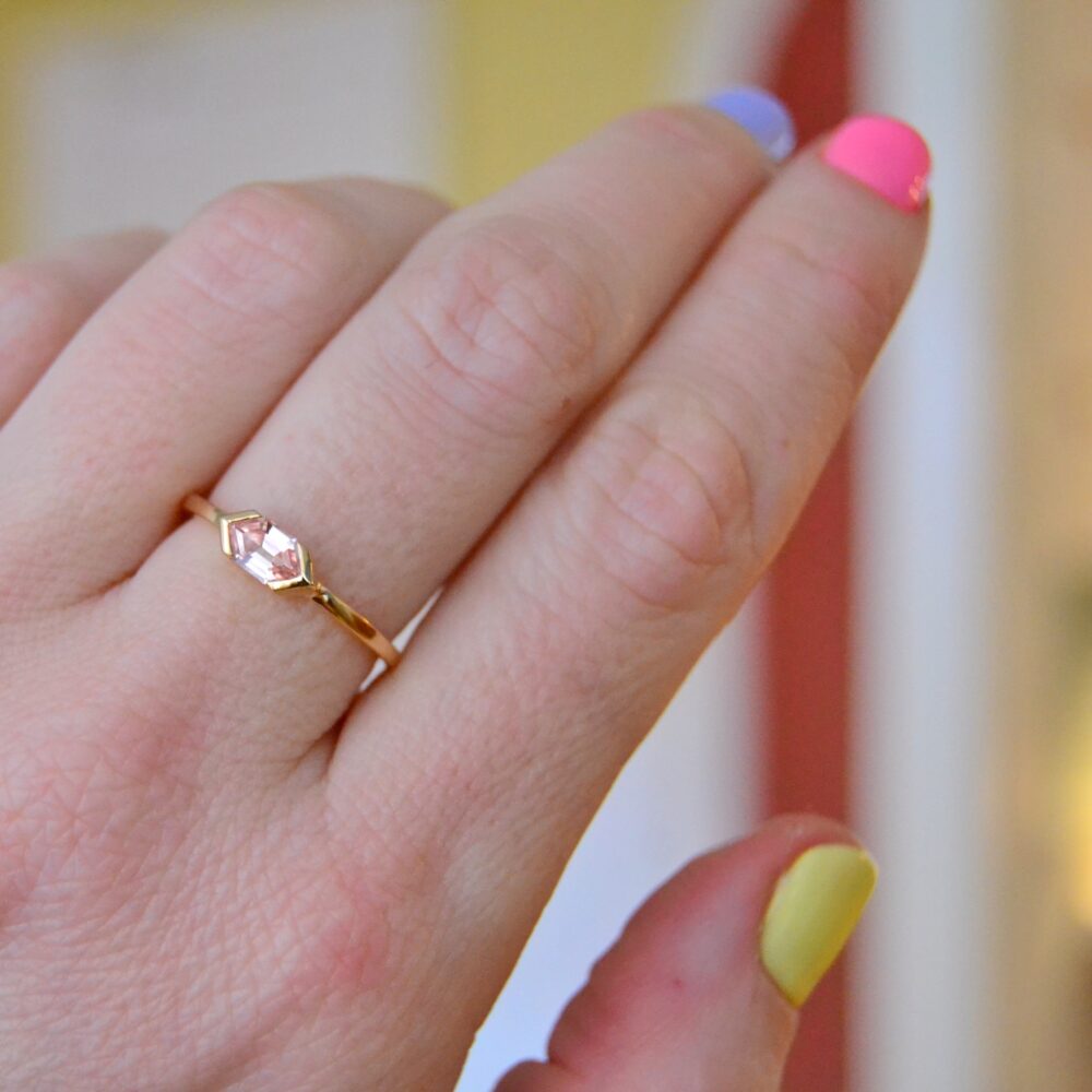Peach sapphire ring set in 18K yellow gold.