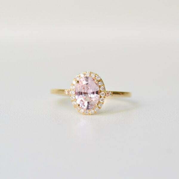 Pink sapphire halo ring made with unheated pink sapphire and VS1-TW diamonds set in 18K yellow gold.