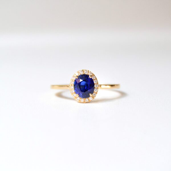 Blue sapphire halo ring with diamonds set in 18K yellow gold.
