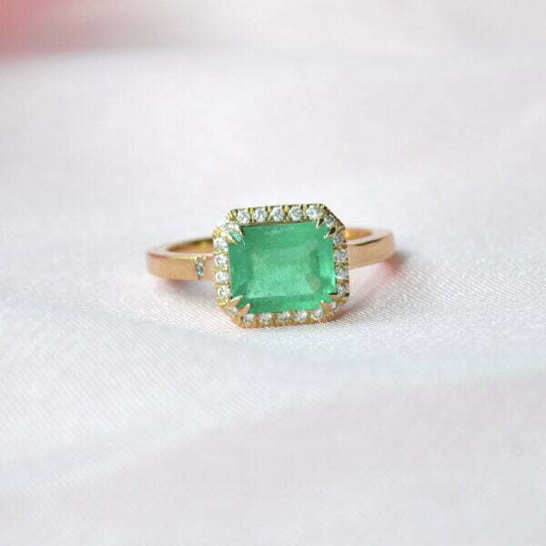 East west ring with emerald