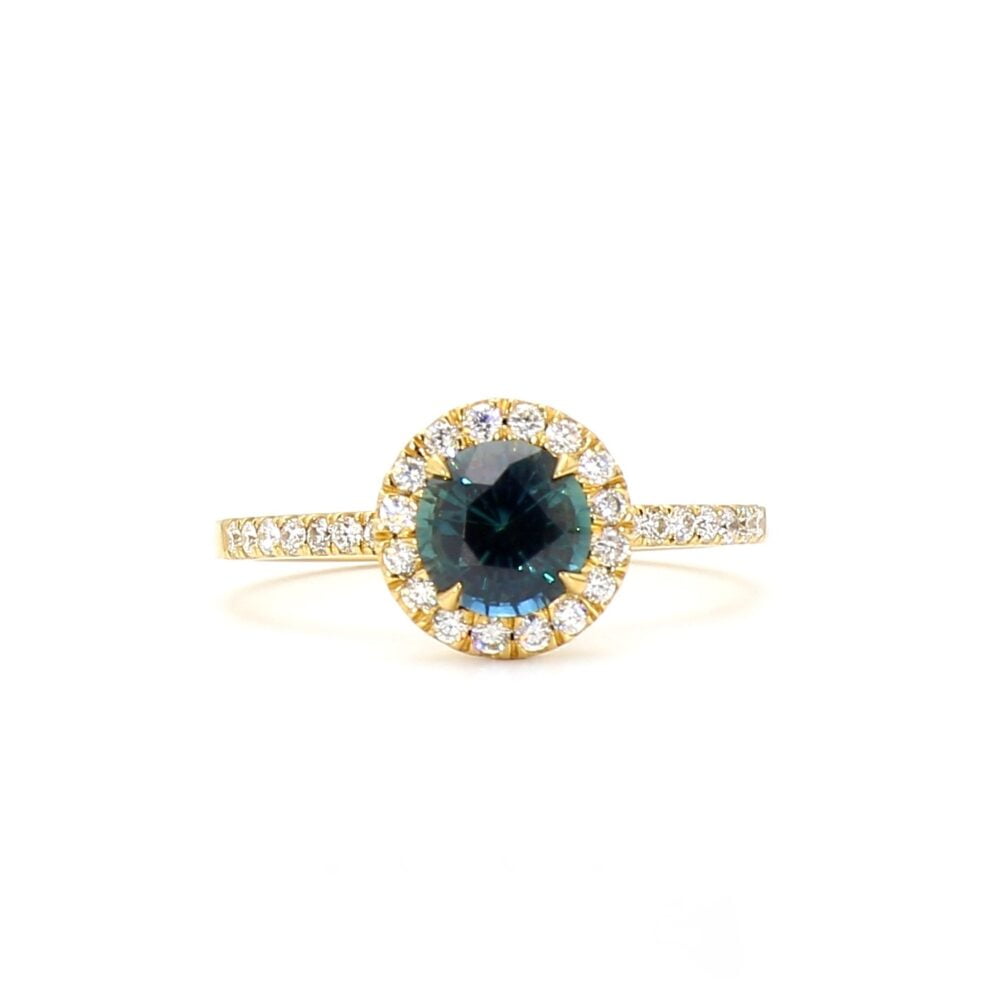 Teal sapphire halo ring with diamonds set in 18K yellow gold